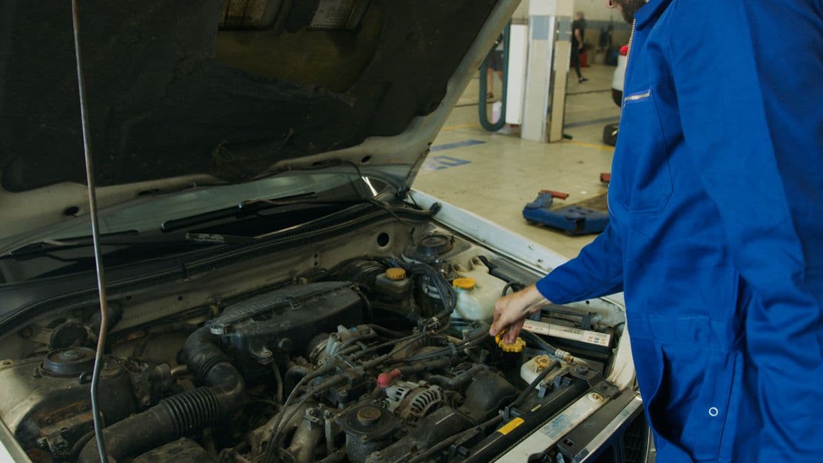 Mechaniker beim Achsvermessen in der Werkstatt